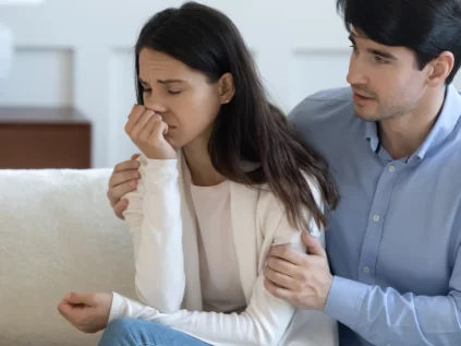 Male partner comforting grieving female partner